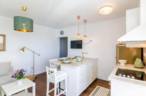 杜布罗夫尼克Apartment Rose Dubrovnik的一间厨房,内设白色橱柜和一张桌子
