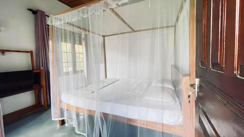 米瑞莎Kiara Sands的一间卧室配有一张天蓬床和窗户