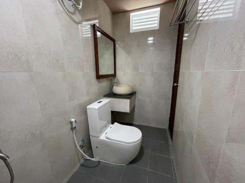 呼拉Courtyard Guesthouse的浴室设有白色的卫生间和镜子