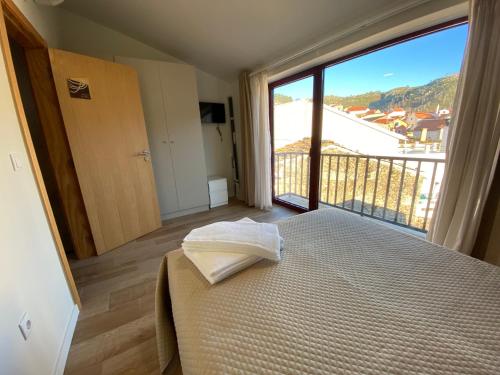 萨布盖鲁Casa dos Conchos 2的一间卧室设有一张床和一个大窗户