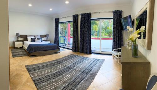 英雄港Chalé d'Angra Guest House的一间卧室设有一张床和一个大窗户