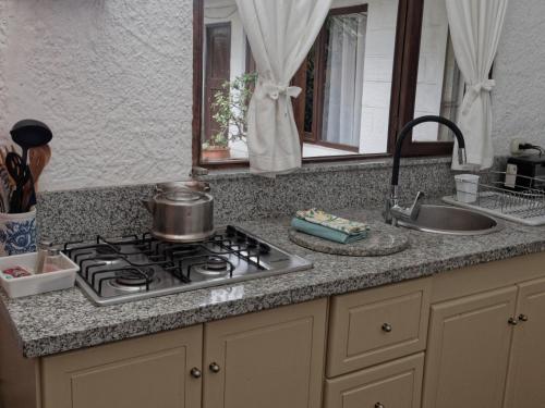 昆卡昆卡厄瓜多尔奥拓罗格公寓式酒店的厨房柜台配有炉灶和水槽
