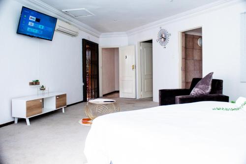 约翰内斯堡Erima Lodge的客厅配有沙发和墙上的电视