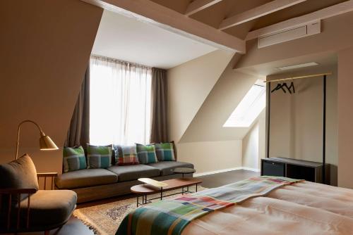 明斯特Central Hotel Münster的一间卧室配有一张床、一张沙发和一个窗口