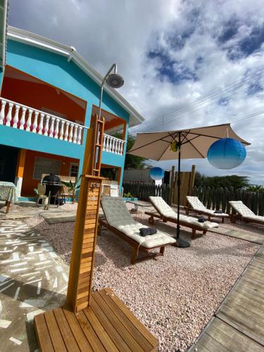 克拉伦代克Poko poko resort的房屋设有带椅子和遮阳伞的庭院