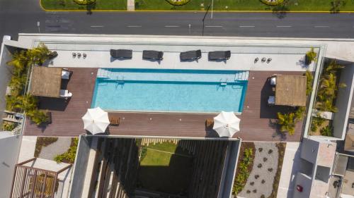 利马✶ Maras Residence ✶ LUXURY Rooftop Pool & Grill的享有带椅子和遮阳伞的游泳池的上方景致