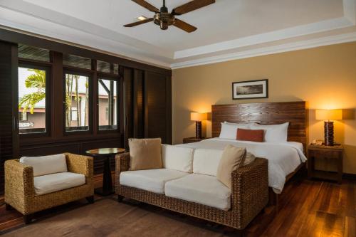 刁曼岛刁曼岛成功度假村的一间卧室配有一张大床和两把椅子