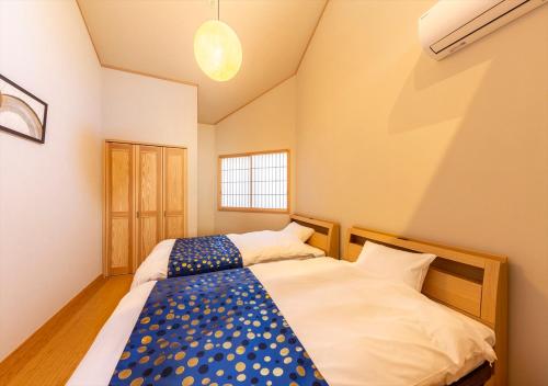 东京YADOYA 夢路的一间卧室设有两张床和窗户。