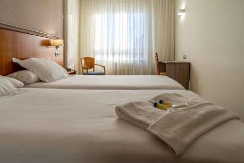 圣地亚哥－德孔波斯特拉康姆波斯特拉苏伊德酒店的酒店客房,配有两张带毛巾的床