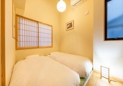 东京YADOYA いろは的带窗户的客房内的两张床