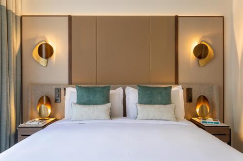 巴黎InterContinental Paris Champs Elysées Etoile, an IHG Hotel的一张大床,位于酒店带两盏灯的房间