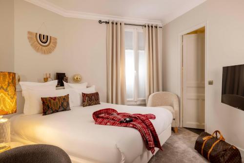 巴黎班维勒酒店的酒店客房的床铺上装有红色围巾