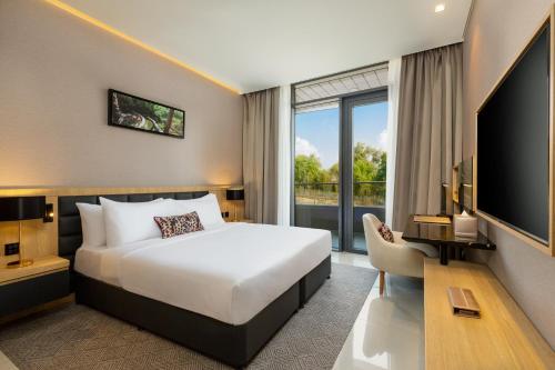 迪拜Millennium Place Mirdif Apartments的酒店客房,配有床和电视