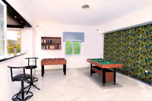 罗希姆诺Villa Sea Horizon的一间设有两张桌子和一张乒乓球桌的房间