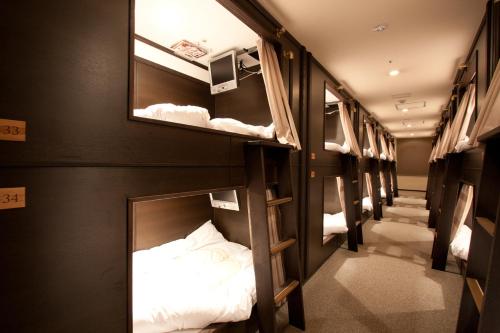 福冈HEARTS Capsule Hotel & Spa Nakasu -Male only-的客房内的一排双层床