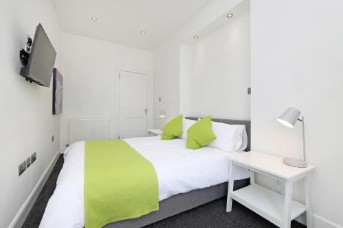 因纳利森One bed apartment in the heart of Innerleithen的卧室配有绿色和白色的床和书桌。
