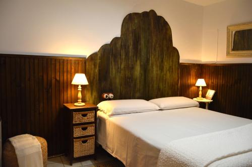 赫尔特卡萨白素娜乡村民宿的一间卧室配有一张大床和木制床头板