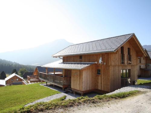 上陶恩Chalet in Hohentauern with hot tub and sauna的山上的木屋,设有太阳能屋顶