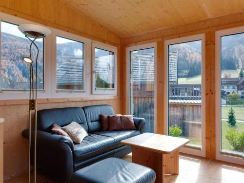上陶恩Chalet in Hohentauern in the ski area的带沙发、桌子和窗户的客厅