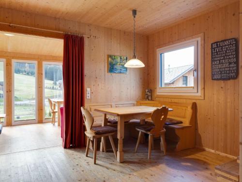 上陶恩Chalet in Hohentauern in the ski area的一间带木桌和椅子的用餐室