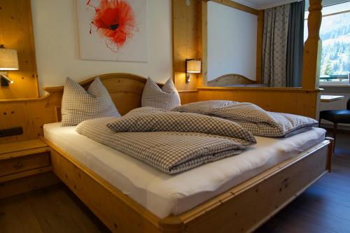 措布伦Garni Hotel Wildanger的一间卧室配有一张带枕头的木床