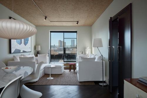 伦敦One Hundred Shoreditch的客厅配有白色家具和大窗户