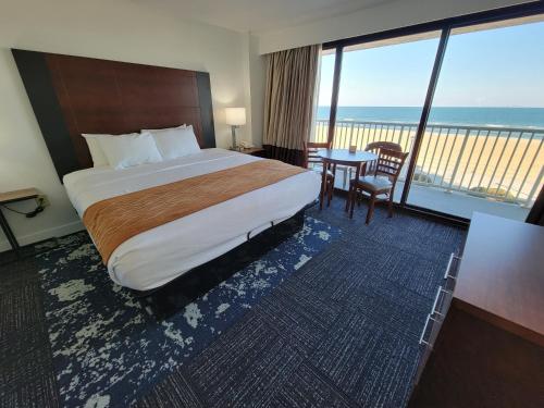 弗吉尼亚海滩Coastal Hotel & Suites Virginia Beach - Oceanfront的酒店客房设有一张床,享有海景。