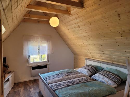 MemlebenFerienhaus Unstrutblick的木天花板的客房内的一张床位