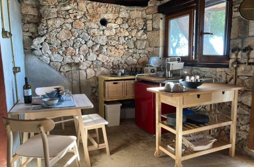 阿尔戈斯托利翁Kamaroules Sea Front的厨房配有木桌和石墙