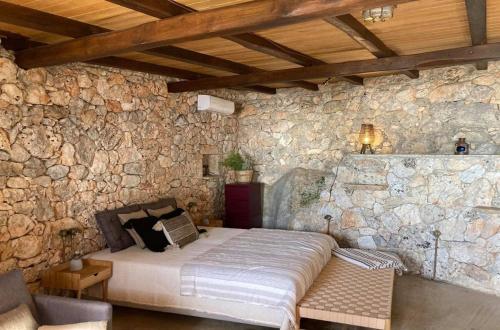 阿尔戈斯托利翁Kamaroules Sea Front的卧室配有一张石墙床
