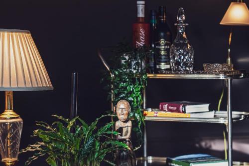 麦克尔斯菲尔德BOHOTEL的桌子,带灯,植物,带瓶子的架子