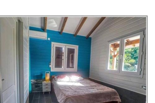 圣安娜Magnifique maison en bois avec piscine的蓝色的客房设有床和窗户。