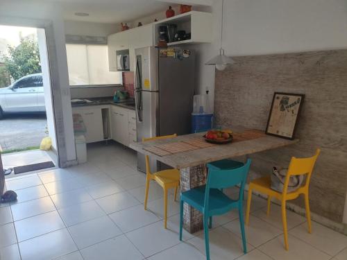 布希奥斯Casa De Búzios的厨房配有桌子、四把椅子和台面