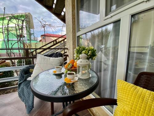 皮聪达Мини-отель ДАРЬЯ в Пицунде的阳台上的桌子上放着杯子和橙子