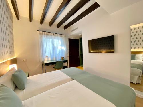 阿拉罗Alaró Natura Rural Suites的一间卧室配有两张床和一张书桌