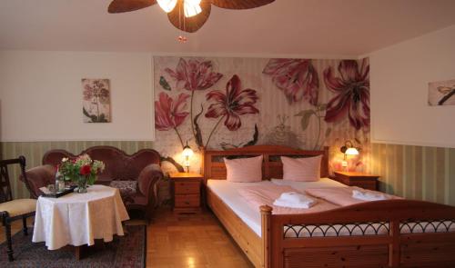 罗滕堡夸泽霍夫伽尼酒店的卧室配有一张床和一张墙上鲜花桌子。
