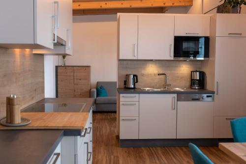 加尔蒂Mountain Lodge的厨房配有白色橱柜和水槽