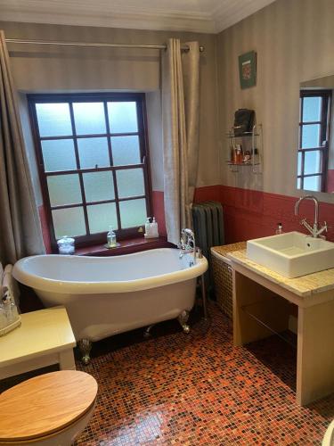 卡迪夫桂冠住宿加早餐旅馆的一间带大浴缸和水槽的浴室