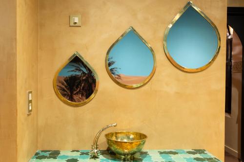 里尔Kechmara hammam&spa的浴室的墙上设有三面镜子和水槽