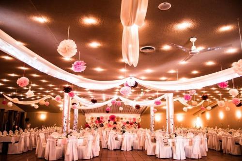 包姚马洛木俱乐部畔兹奥住宿加早餐旅馆的宴会厅配有白色桌子和粉红色的鲜花