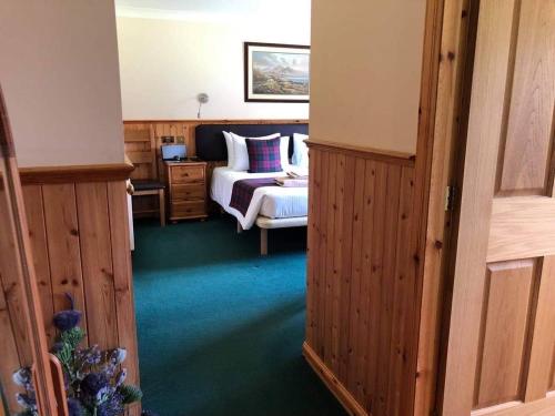 Glenmoriston宾尼里德莫霍住宿加早餐酒店的一间卧室配有一张床和一张床,另一间卧室配有一张床。