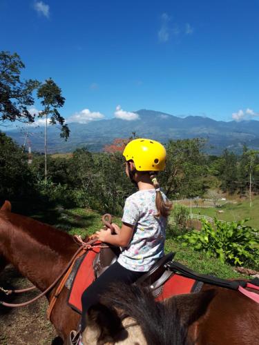 Tres EquisFinca Tres Equis - Farm and Forest的骑马后边的小女孩