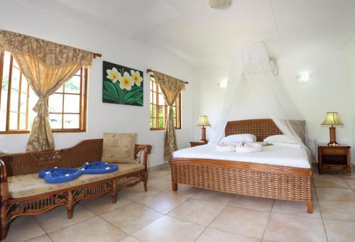 拉迪格岛乐苏莫度假小屋的一间卧室配有一张床、一张沙发和窗户。
