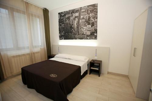 西维尔诺瓦·马尔凯Orchidea Rooms & Suites的一间卧室配有一张带黑桌的床