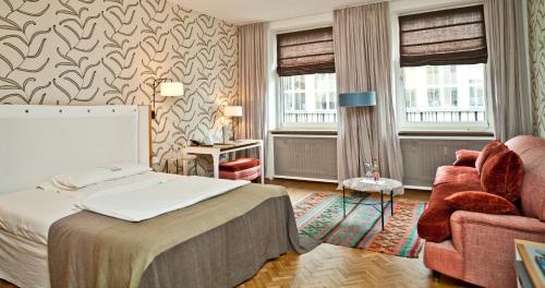 慕尼黑科尔提娜酒店的配有一张床和一把椅子的酒店客房