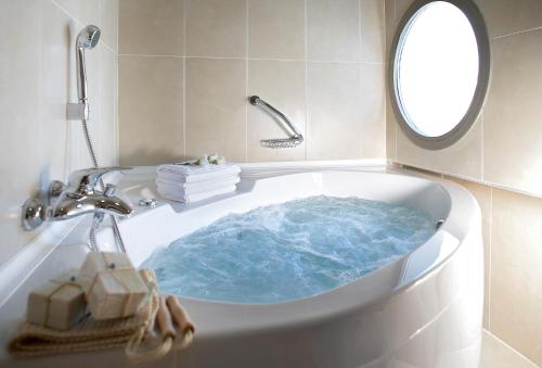 马尔马里斯Emre Beach & Emre Hotel的浴室设有装满蓝色水的浴缸。