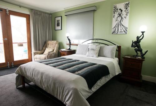 奥尔巴尼Kinsellas Water Views的一间卧室配有一张大床和一把椅子