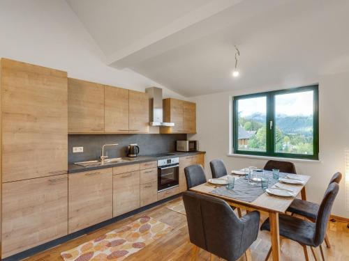 上陶恩Apartment in Hohentauern near ski area的带桌椅的厨房和带窗户的厨房