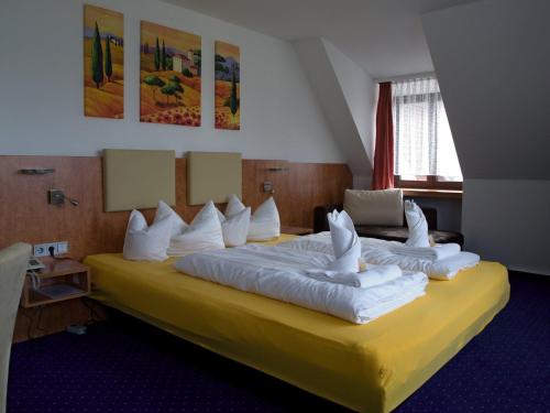 Rednitzhembach赫姆巴切尔豪弗酒店的酒店客房配有一张带白色枕头的大床