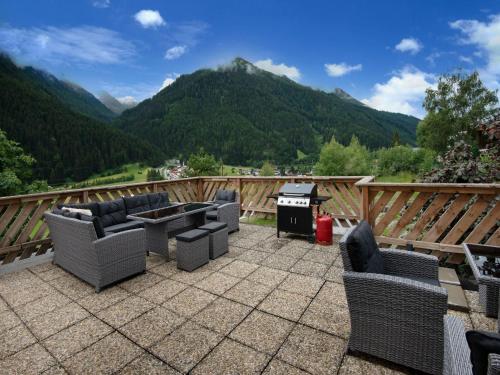 圣安东阿尔贝格Holiday home near St Anton am Arlberg with sauna的一个带椅子和烧烤设施的庭院